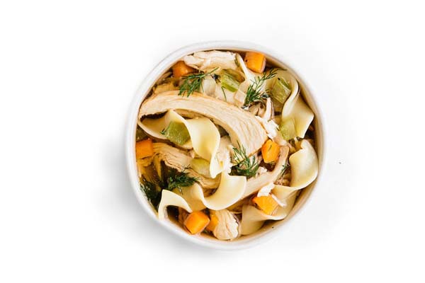 Chicken noodle soup with wide egg noodles, shredded chicken, carrots, celery, and dill.