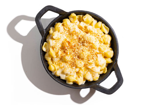 Classic mac and cheese in a skillet, topped with golden breadcrumbs.