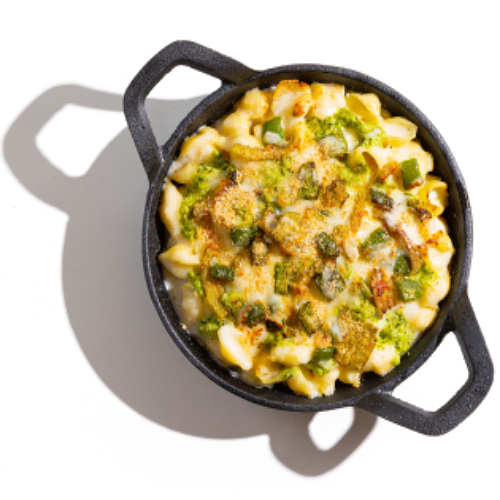 Skillet of baked mac and cheese with broccoli, green peppers, and melted cheese.