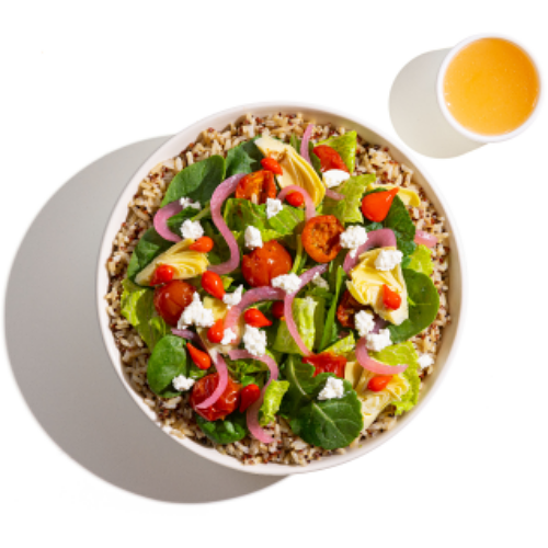 Grain bowl topped with spinach, cherry tomatoes, pickled onions, artichokes, goat cheese, and served with vinaigrette.