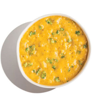 Cheddar broccoli soup with visible broccoli florets in a thick yellow cheese base.
