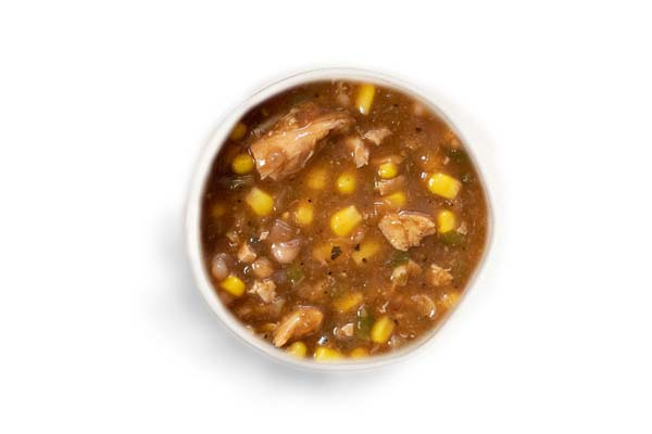 Southwestern-style soup with chunks of chicken, corn, and beans in a brown broth.
