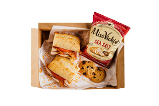 A box with a sandwich, chips and dessert.