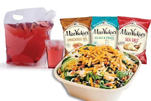 A salad with grilled chicken and tortilla strips, served with fruit punch and three bags of Miss Vickie’s chips.